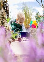 Jeune enfant jouant dans le jardin sensoriel