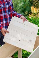 Insérer une base en bois dans une jardinière construite à partir d'un kit
