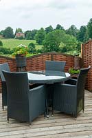 Table et chaises en rotin sur terrasse en bois avec vue dégagée sur le parc - Journée des jardins ouverts, Coddenham, Suffolk