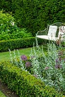 Siège de jardin avec coussins, entre parterres de roses, géraniums bleus, Artemisia et Alliums, tous avec bordure de boîte - Journée des jardins ouverts, Coddenham, Suffolk