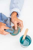 Femme à l'aide d'un chiffon pour essuyer l'excès de peinture du plat