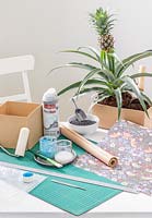 Outils et matériaux nécessaires pour fabriquer une boîte en carton plantée décorée de papier d'emballage