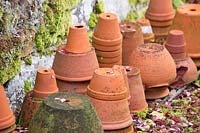 Des piles de pots en terre cuite retournés par mur