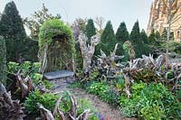 Le jardin Stumpery au printemps avec des rondins sculpturaux décoratifs et un siège de sculpture vivant. Château d'Arundel, West Sussex, Royaume-Uni.