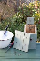 Bird Box sur table avec couvercle retiré prêt pour le nettoyage avec un désinfectant et de l'eau en hiver prêt pour la nidification des oiseaux au printemps