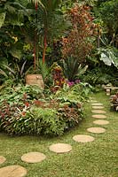 Chemin de pavés circulaires dans un jardin tropical