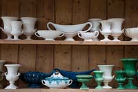 Collection de vases et d'urnes blancs, bleus et verts dans l'atelier de composition florale.