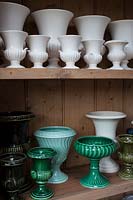 collection de vases et d'urnes blancs et verts dans l'atelier de composition florale.