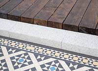 Terrasse en bois au-dessus des marches en pierre avec détail de patio en mosaïque. The Style and Design Garden, sponsorise CED Stone, London Mosaic, Garden Brocante Online -