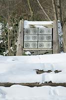 Hôtel d'abeilles en haut des escaliers recouverts de neige.