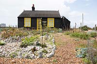 Cottage et jardin sur une plage de galets parterre de pierres blanches