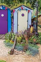 Cabines de plage colorées avec des toits verts de fleurs sauvages. Fun on Sea, RHS Hampton Court Palace Flower Show, 2017. Conception: Tony Wagstaff.