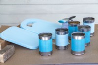 Boîtes de conserve et planches de bois peintes en bleu avant l'assemblage