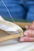 Utiliser un fil fin pour fixer l'extrémité du bâton de bambou à l'intérieur de la poche de l'organisateur de chaussures