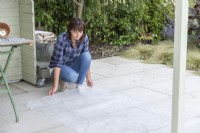 Femme plaçant une feuille de plastique sur le sol pour récupérer le compost en vrac