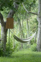 Poème sur panneau en bois près d'un hamac entre deux arbres.