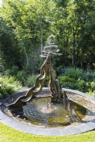 Fontaine sur structure en bois au-dessus de la piscine réalisée par Jane Hazelwood