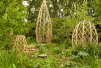 Quatre structures en bambou stratifié entourées d'une piscine remplie de plantes aquatiques situées dans un vallon boisé de Guangzhou en Chine : Guangzhou Garden, lauréat du prix du meilleur jardin d'exposition.