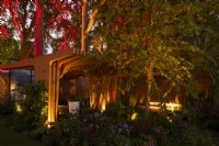 Éclairage dramatique autour du pavillon en bois moderne et des arbres environnants dans le jardin Florence Nightingale.