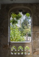 Vue par la fenêtre en pierre sur le jardin.
