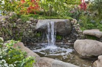 Jeux d'eau dont une petite cascade et une piscine. Le jardin du Psaume 23 au Chelsea Flower Show 2021.