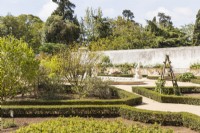 Vue sur parterres végétaux bordés de fort vers mur avec parterres surélevés. Le Jardin Botanique. Queluz, Lisbonne, Portugal, septembre.