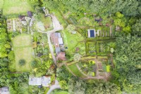Vue sur tout le jardin et les bois environnants avec maison au centre de l'image ; image prise avec un drone. Septembre. L'été.
