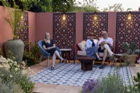 Détente en famille autour d'un foyer dans leur patio de jardin de style marocain