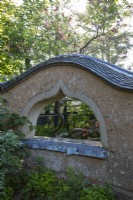 Structure murale en torchis dans le jardin, avec fenêtre en arc 'judas'