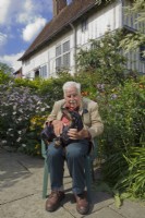 Christopher Lloyd avec pet teckel à côté du long parterre de fleurs à Great Dixter, East Sussex, Angleterre