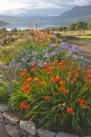Parterre de fleurs surélevé avec des plantes de l'hémisphère sud, y compris Crocosmia, Agapanthus, Watsonia et Kniphofia avec vue vers Little Loch Broom.2 Durnamuck, Little Loch Broom, Ross-shire, Scotland