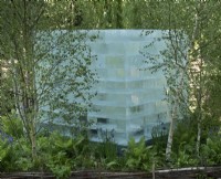 Bloc de glace géant dans un cadre boisé.