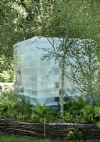 Bloc de glace géant dans un jardin boisé sibérien avec une clôture en bois taillis naturel