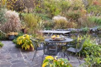 Aire de détente, bassin et platebande colorée avec graminées, vivaces et arbustes. Jardin de Gisi Helmberger, Autriche
