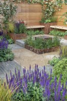 De simples bancs en bois donnent sur une pièce d'eau réfléchissante dans le jardin de la pause déjeuner au RHS Hampton Court Palace Garden Festival 2022