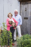 Couple avec chien debout près d'une porte