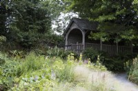 La maison d'été au-dessus du jardin de la carrière avec des graminées et des vivaces compactes. La maison du jardin, Yelverton, Devon. Été.