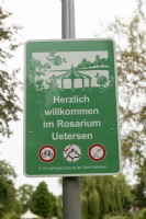 Uetersen AllemagneHerzlich willkomen im Rosarium Uetersen. panneau de bienvenue avec règles, pas de vélo, chiens en laisse et ne nourrissez pas la sauvagine
