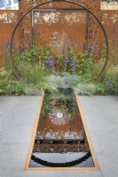 Moongate en acier Corten et reflets dans la piscine du jardin Sunburst au RHS Hampton Court Palace Garden Festival 2022