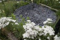 Trempage circulaire en ardoise dans le jardin Connections au RHS Hampton Court Palace Garden Festival 2022