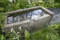 Abreuvoir en pierre dans le jardin des connexions au RHS Hampton Court Palace Garden Festival 2022