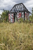 Cottage ukrainien brûlé dans un champ d'orge dans le jardin Ce qui ne brûle pas au RHS Hampton Court Palace Garden Festival 2022