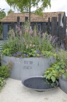 Jardinières industrielles récupérées circulaires dans le jardin de la vitamine G au RHS Hampton Court Palace Garden Festival 2022