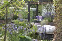 Pergola carbonisée au-dessus du coin salon dans le jardin des traces d'Abigail au RHS Malvern Spring Festival 2022