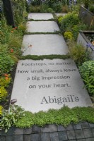 Chemin avec message bordé de plantes vivaces dans le jardin des pas d'Abigail au RHS Malvern Spring Festival 2022