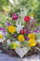 Arrangement floral printanier avec tulipes, jonquilles, pissenlit, persil de vache, honnêteté et lamier.