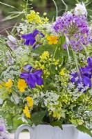 Bouquet de fleurs printanières contenant de l'allium, de l'iris, des vivaces à fleurs sauvages et des graminées.
