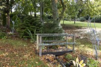 Un pont sur un petit ruisseau dans un jardin informel de style campagnard. Whitstone Farm, Devon NGS jardin, automne
