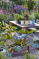 Ensembles de sièges d'extérieur et pots plantés d'herbes et de légumes.