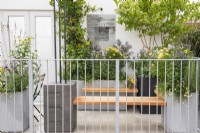 Bancs en bois attachés à de grandes jardinières avec plantation de vivaces à la fin de l'été - The Landform Balcony Garden, RHS Chelsea Flower Show 2021